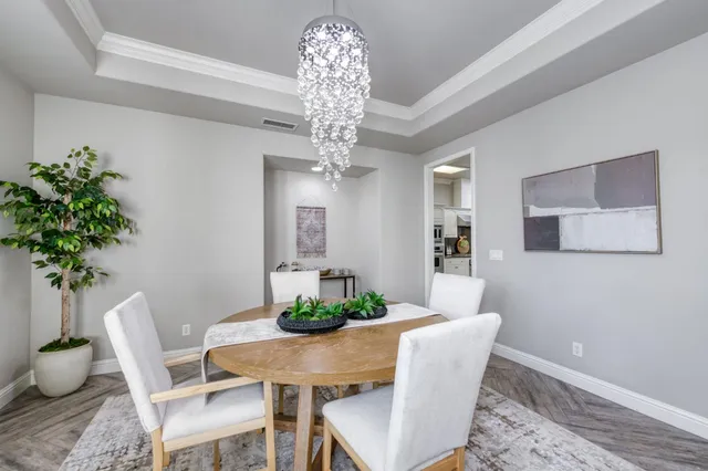 a dining room with furniture potted plants and wooden floor