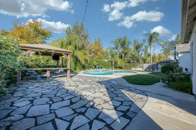 a view of a yard with plants and a fountain