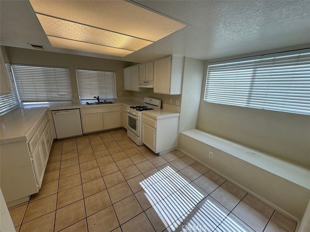 13080 Mohican Drive Moreno Valley, CA 92555 - Photo 17 of 38 a kitchen with a sink a stove and cabinets