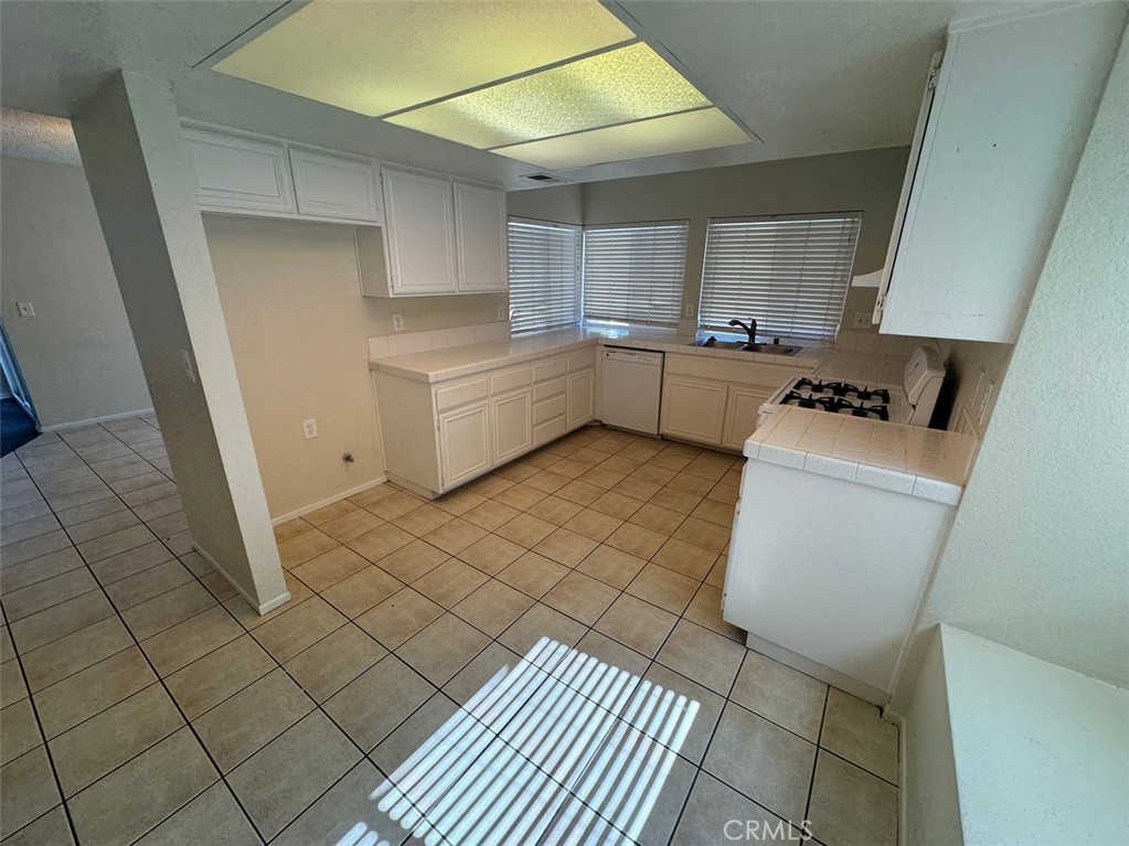 13080 Mohican Drive Moreno Valley, CA 92555 - Photo 18 of 38 a kitchen with a sink a stove and cabinets