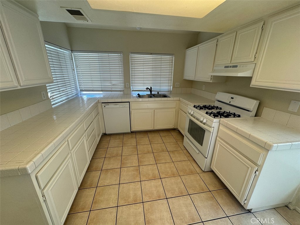 13080 Mohican Drive Moreno Valley, CA 92555 - Photo 19 of 38 a kitchen with a stove a sink and a refrigerator