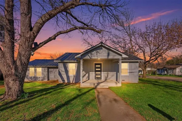 a front view of a house with yard and green space
