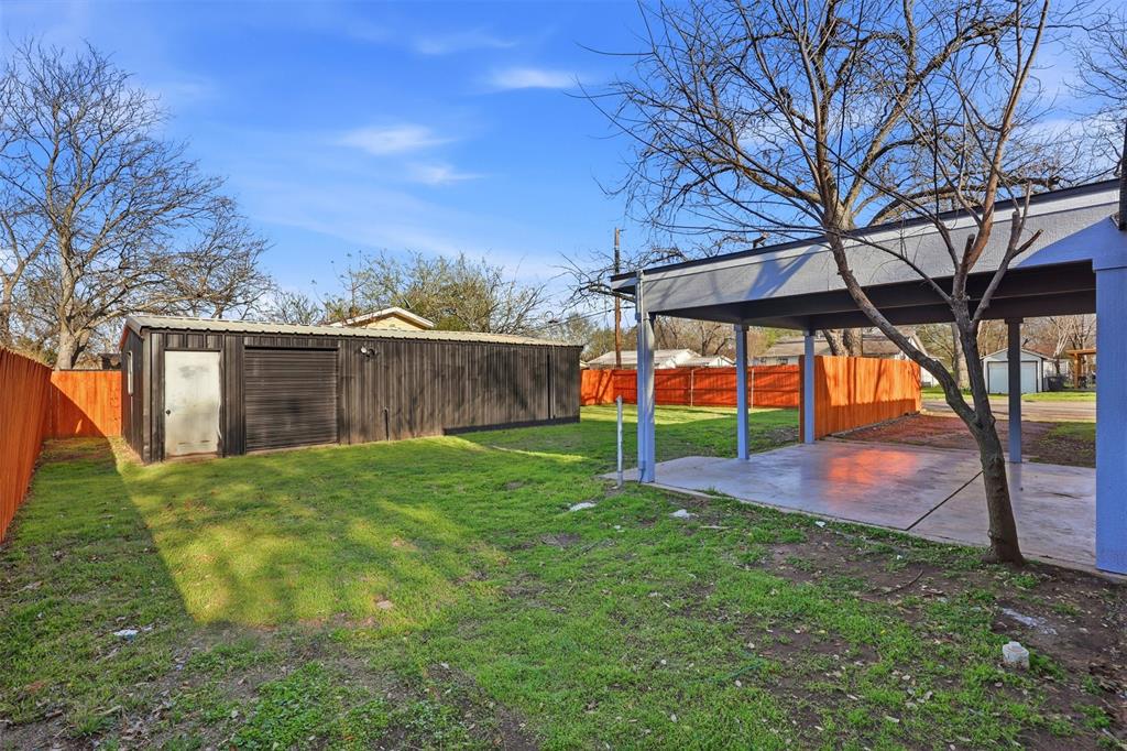 502 Madison Street Cleburne, TX 76033 - Photo 2 of 30 View of backyard featuring a covered carport/ patio with large work