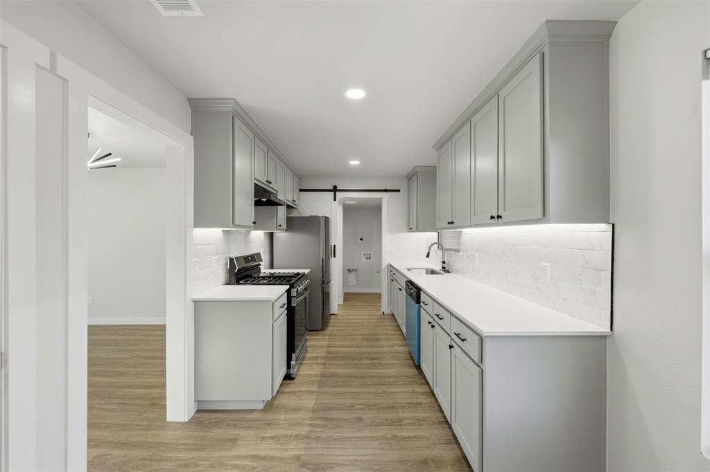502 Madison Street Cleburne, TX 76033 - Photo 8 of 30 Kitchen with sliding barn door to full size utility room.