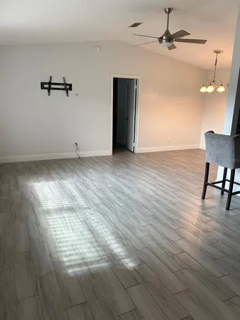 a view of a room with wooden floor and ceiling fan
