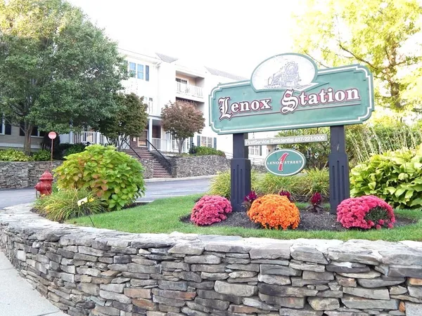 a view of a hallway with wooden floor and a living room