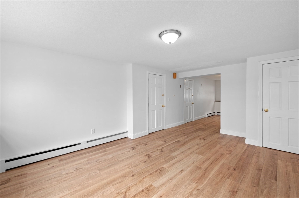 121 Cambridge Road, Unit 2 Woburn, MA 01801 - Photo 7 of 23 a view of an empty room and wooden floor