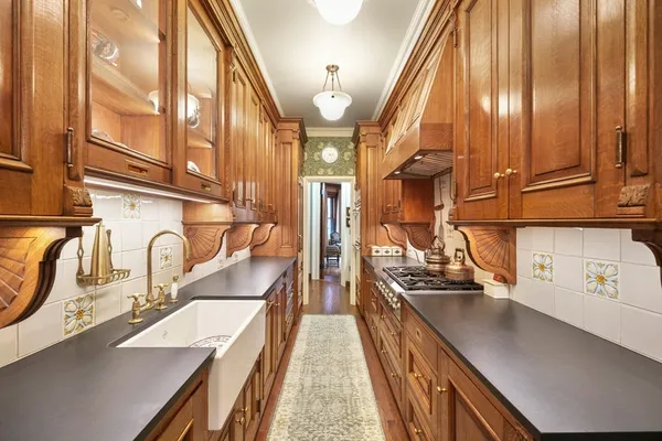 a kitchen with stainless steel appliances granite countertop a sink a stove and a wooden floors