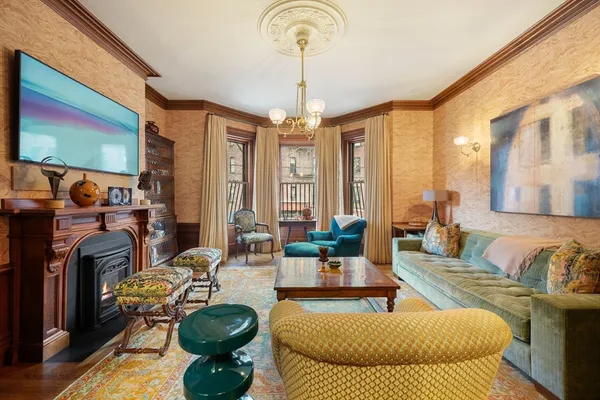a living room with fireplace furniture and a large window