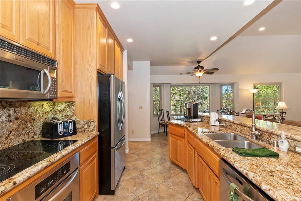 24310 Albrun Drive Crestline, CA 92325 - Photo 12 of 39 a large kitchen with granite countertop a large window and stainless steel appliances