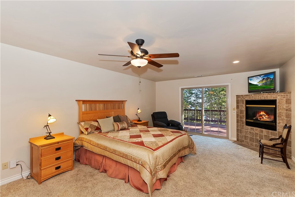24310 Albrun Drive Crestline, CA 92325 - Photo 15 of 39 a living room with furniture a fireplace and a flat screen tv