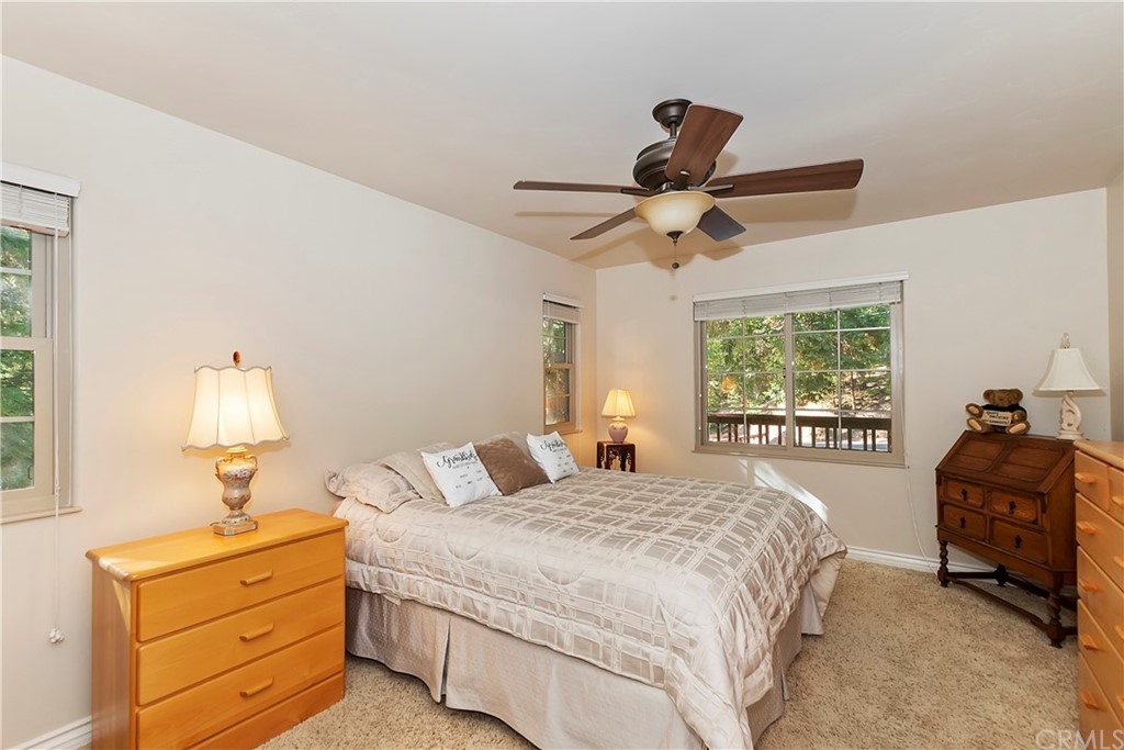 24310 Albrun Drive Crestline, CA 92325 - Photo 21 of 39 a bedroom with a bed and a chandelier