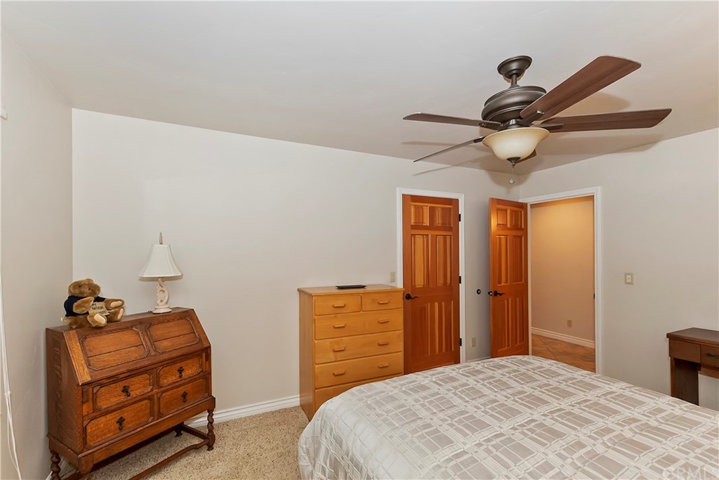 24310 Albrun Drive Crestline, CA 92325 - Photo 22 of 39 a bedroom with a bed and a chandelier