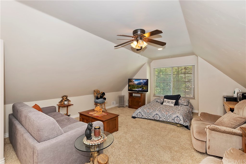 24310 Albrun Drive Crestline, CA 92325 - Photo 26 of 39 a living room with furniture a flat screen tv and a large window