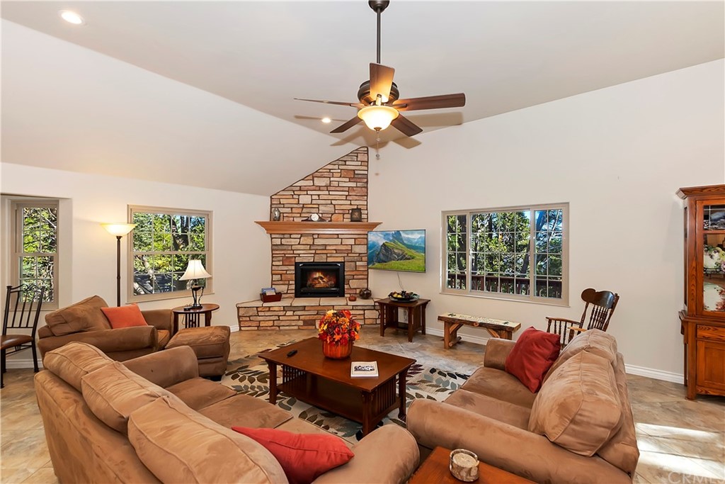 24310 Albrun Drive Crestline, CA 92325 - Photo 6 of 39 a living room with furniture a fireplace and a chandelier
