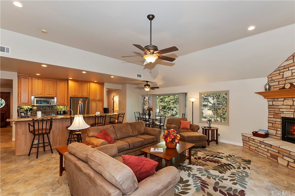 24310 Albrun Drive Crestline, CA 92325 - Photo 7 of 39 a living room with furniture a fireplace and a chandelier