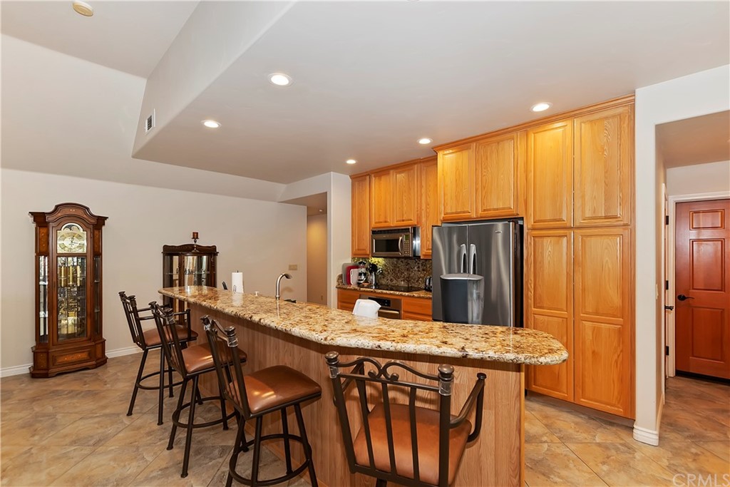 24310 Albrun Drive Crestline, CA 92325 - Photo 10 of 39 a kitchen with stainless steel appliances granite countertop a table chairs sink refrigerator and microwave