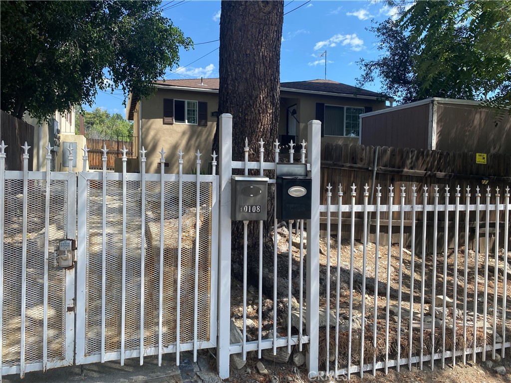 a view of a house with a small yard and wooden fence
