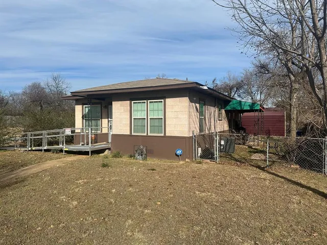 a view of a house with backyard and sitting area