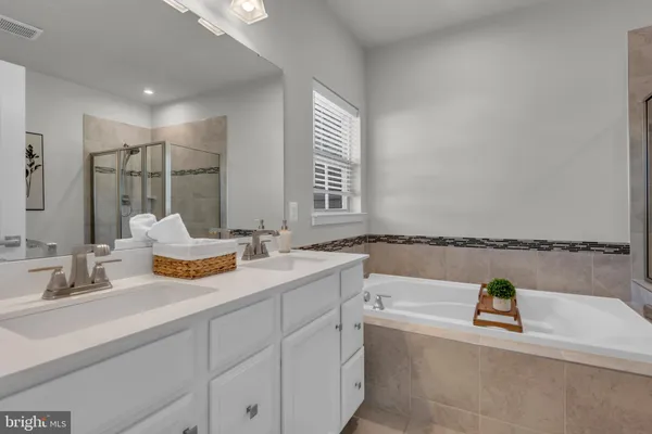 a bathroom with a tub sink and mirror