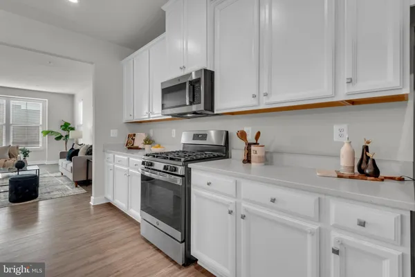 a kitchen with white cabinets and appliances