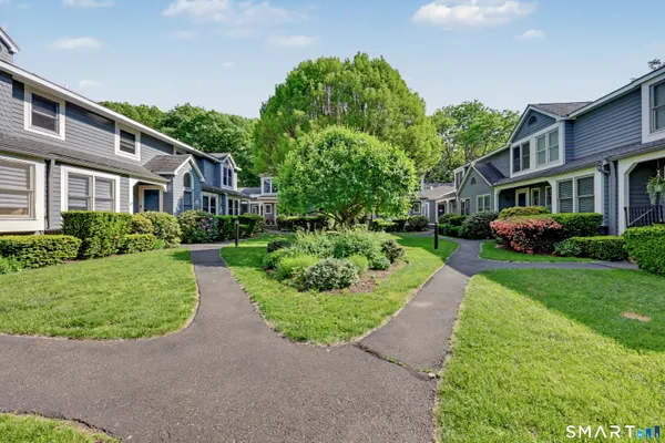 a front view of a house with a yard and potted plants