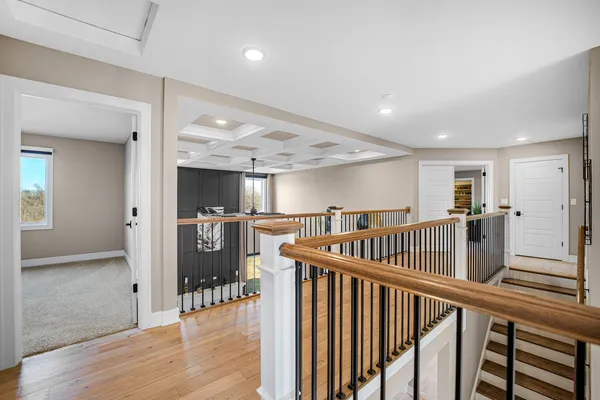 a view of a bedroom with wooden floor and windows