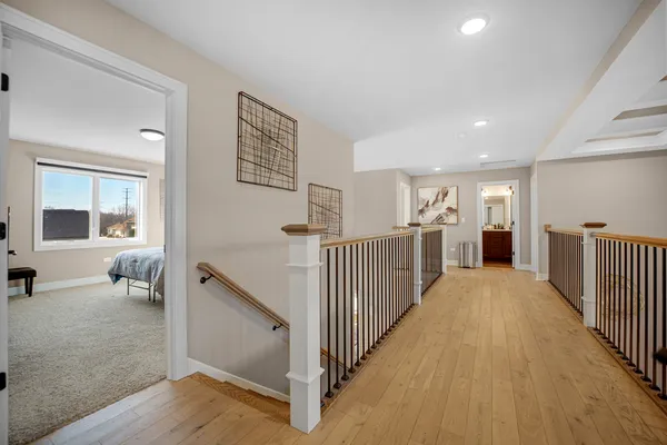 a view of a hallway with wooden floor and staircase
