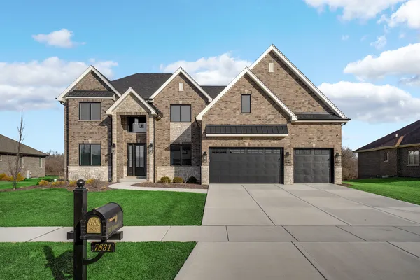 a front view of a house with a yard and trees