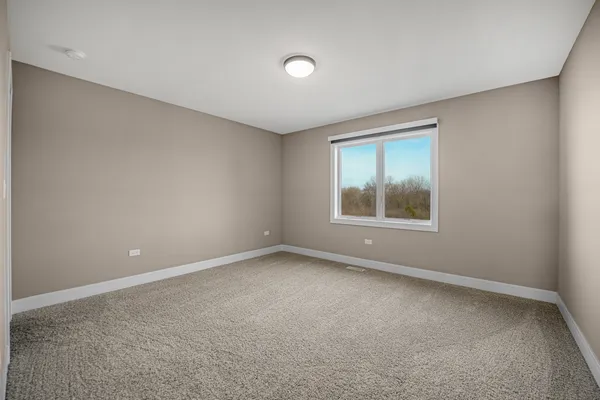 a bedroom with a bed a flat screen tv and guitar