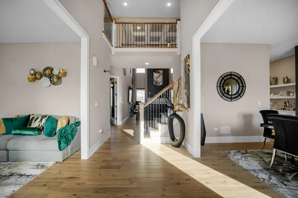 a hallway with a stove a clock and a dining table with wooden floor