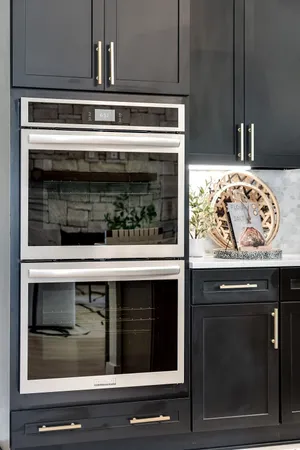 a kitchen with stainless steel appliances kitchen island granite countertop a refrigerator a stove a microwave oven a sink with island chairs and wooden floor