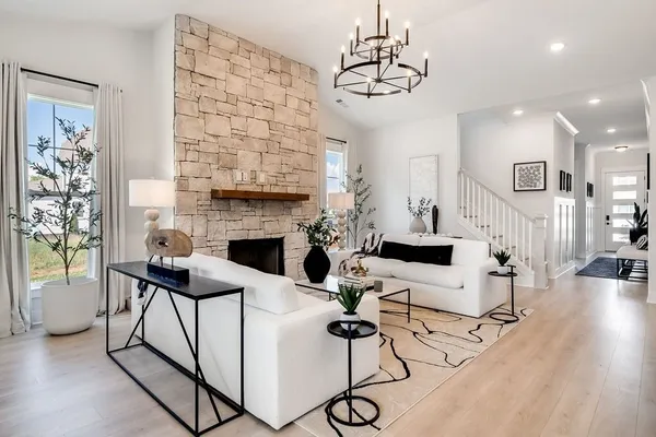 a living room with furniture a fireplace and a chandelier