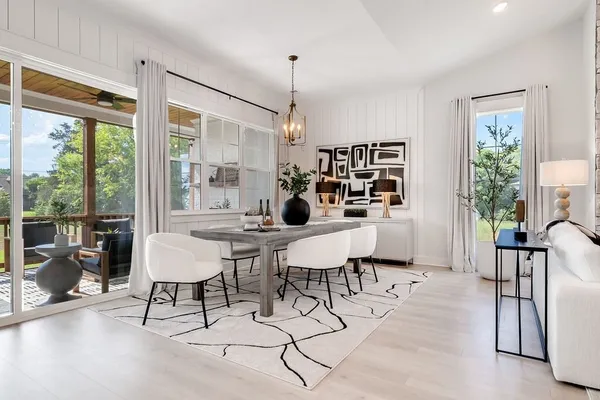 a living room with furniture a dining table and a large window