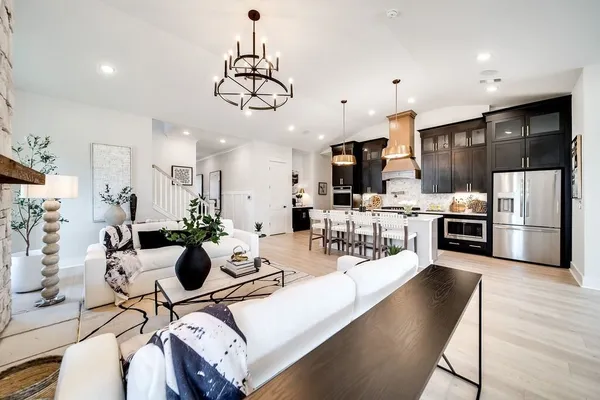 a kitchen with a dining table cabinets stainless steel appliances and wooden floor