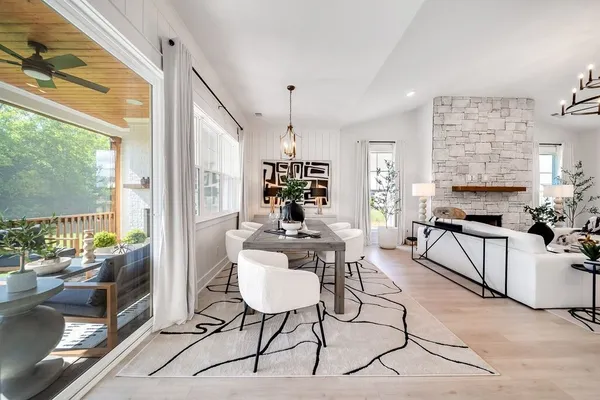 a living room with furniture a dining table and a floor to ceiling window