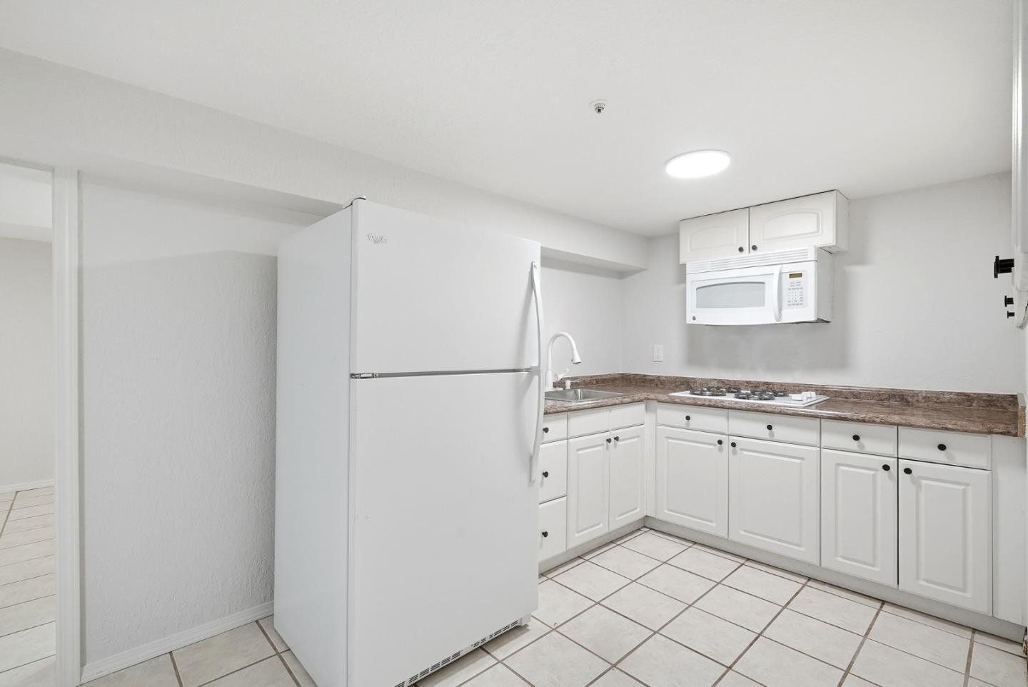 320 Angel Avenue Sunnyvale, CA 94086 - Photo 29 of 47 a kitchen with granite countertop white cabinets and refrigerator