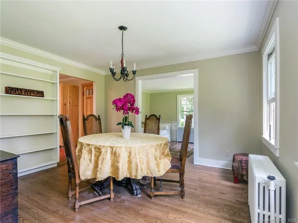 a dining room with furniture window and wooden floor