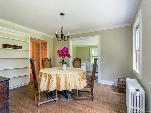 a dining room with furniture window and wooden floor