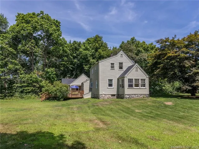 a front view of a house with a yard and trees