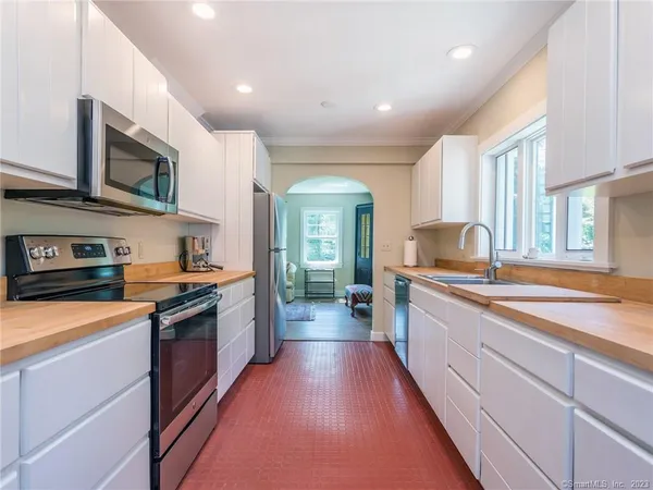 a large kitchen with stainless steel appliances granite countertop a stove and a sink