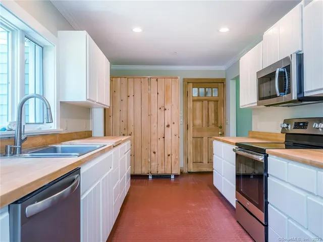 a kitchen with a sink stove top oven and refrigerator