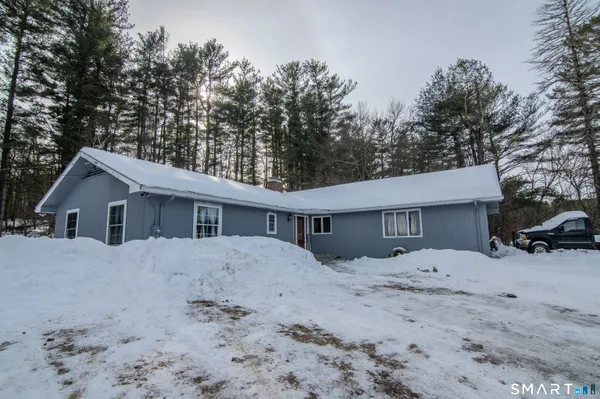 a front view of a house with a yard covered in snow