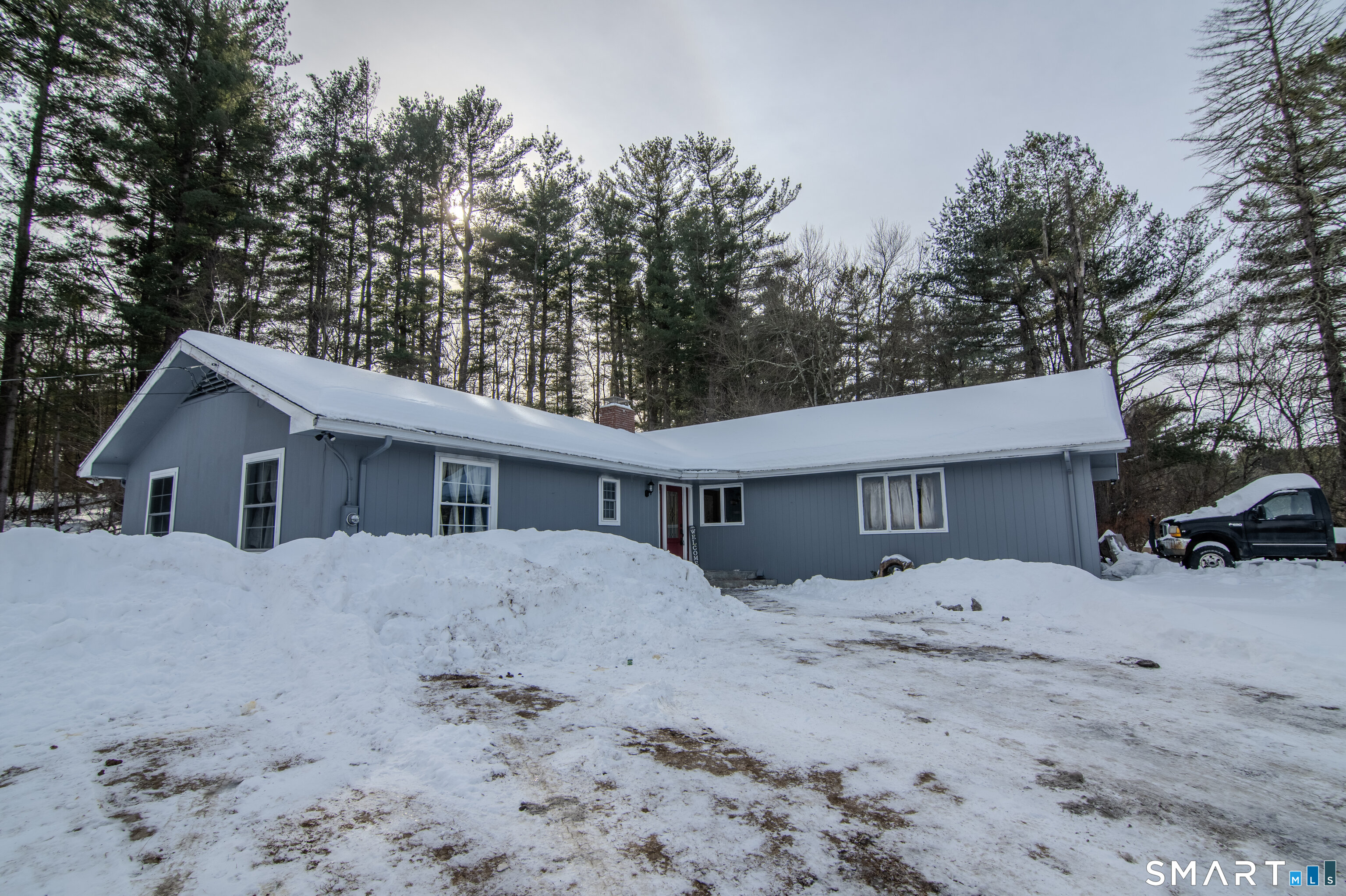 310 Roseland Park Road Woodstock, CT 06281 - Photo 13 of 43 a front view of a house with a yard covered in snow