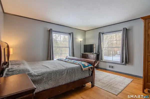 a bedroom with a bed and wooden floor
