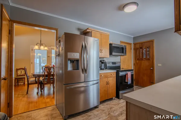 a kitchen with stainless steel appliances granite countertop a refrigerator a stove top oven a sink and dishwasher
