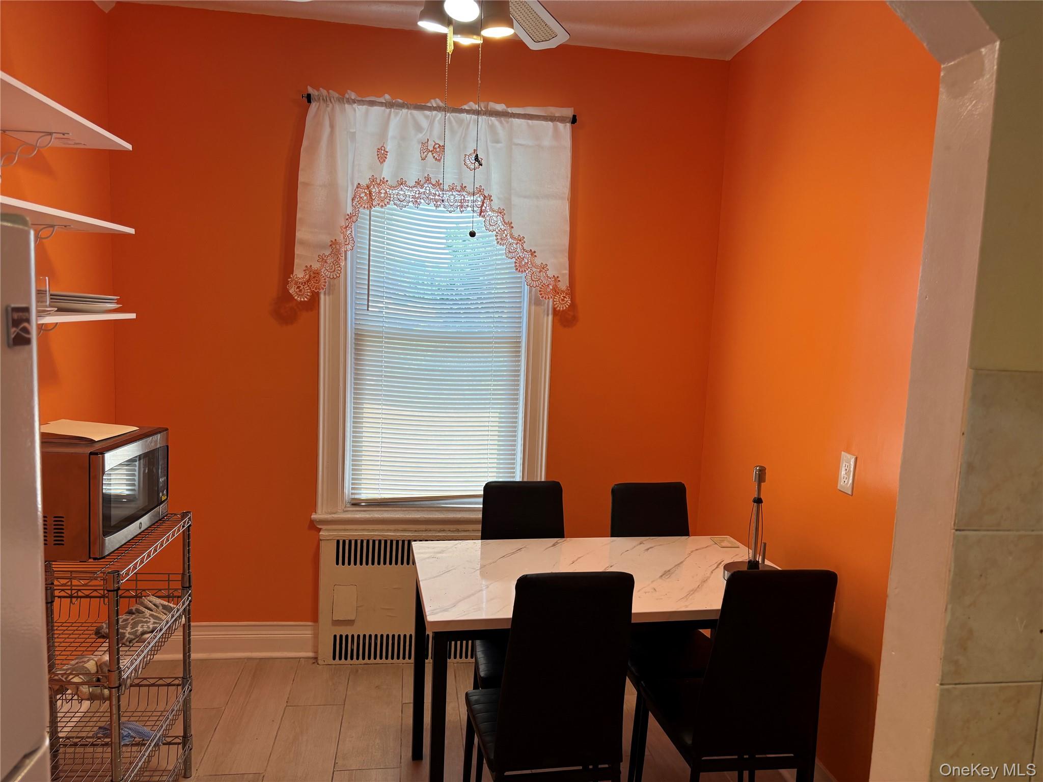 1004 Lenox Road Brooklyn, NY 11212 - Photo 6 of 13 Dining area featuring a window with blinds, wood-finish flooring, and a ceiling fan with light fixture