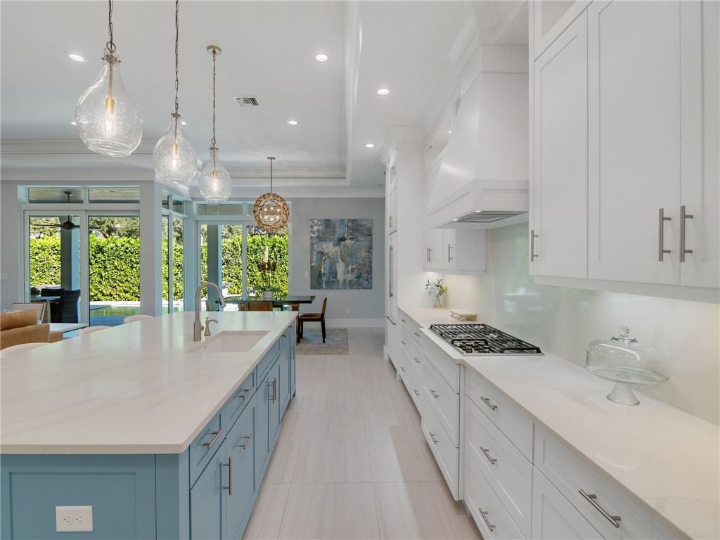 1025 Andarella Way Vero Beach, FL 32963 - Photo 14 of 36 a kitchen with granite countertop a stove a sink a center island and windows