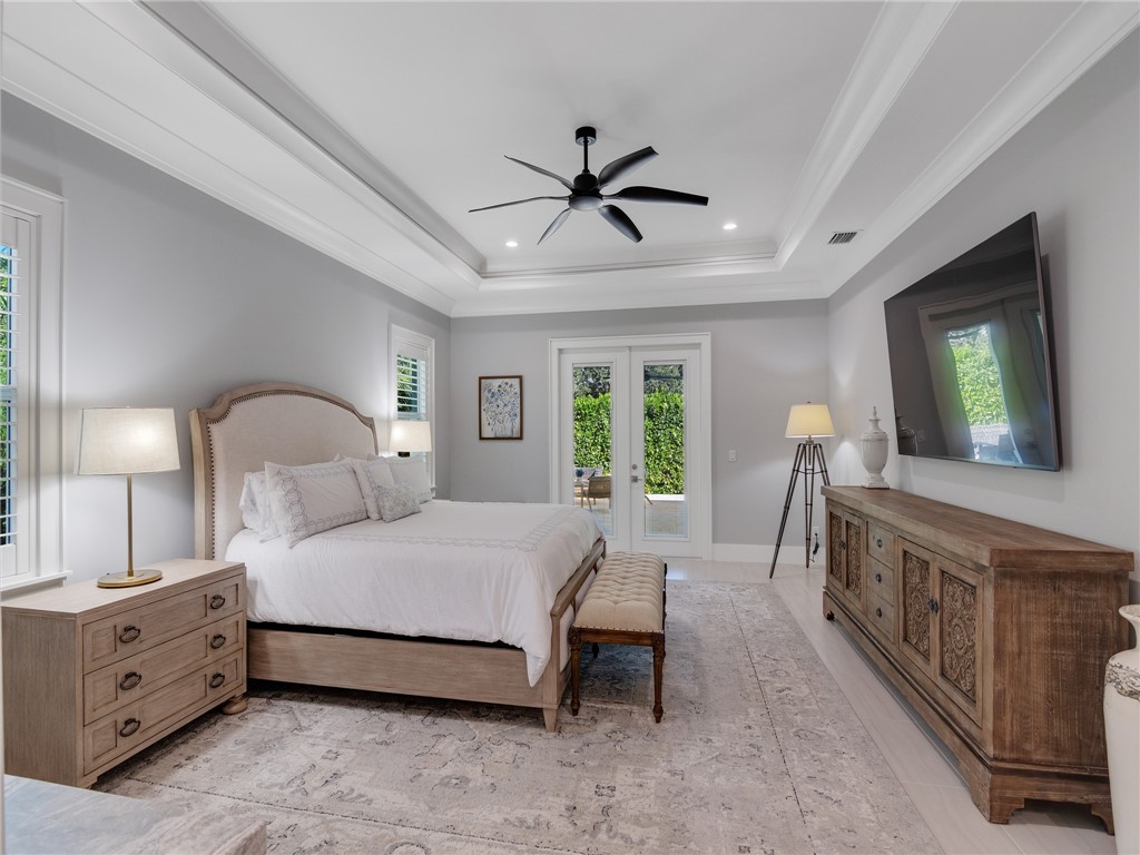 1025 Andarella Way Vero Beach, FL 32963 - Photo 18 of 36 a spacious bedroom with a bed and a chandelier
