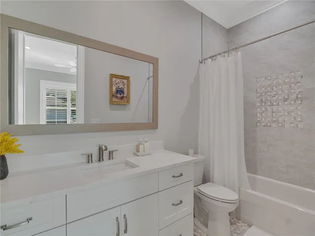 a bathroom with a sink mirror vanity and toilet